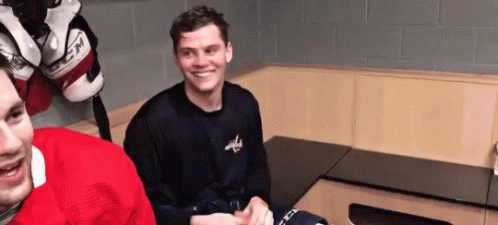 Two Hockey Players Smiling in Locker Room