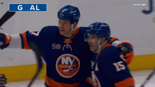 Two Ice Hockey Players Are Celebrating A Goal With A Goal Sign Above Them GIF