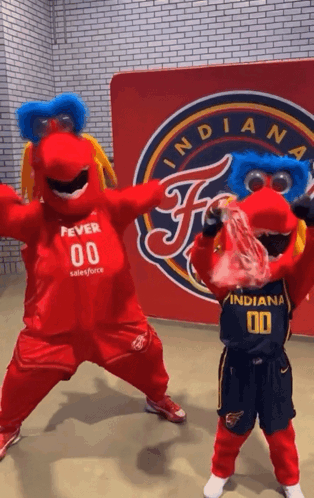 Two Indiana Mascots Are Dancing In Front Of A Sign That Says Indiana GIF