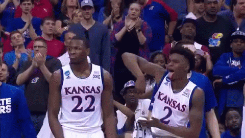 Two Kansas Basketball Players Are Standing In Front Of The Crowd GIF