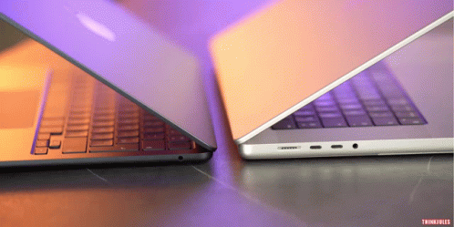 Two Laptops Are Sitting Side By Side And One Has The Word Thinkfiles On The Bottom GIF