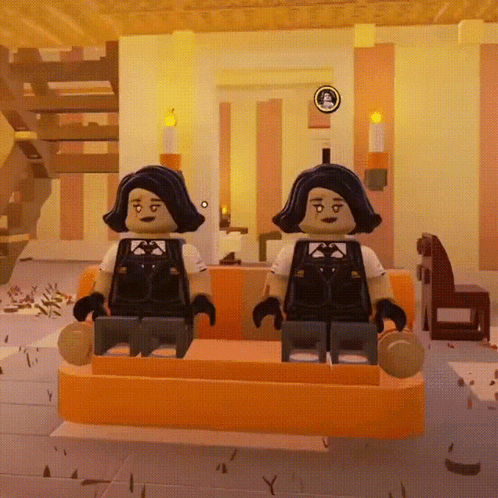 Two Lego Figures Are Sitting On A Orange Couch In A Room GIF