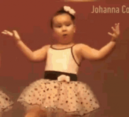 Two Little Girls Are Dancing Together In Tutus On A Stage . GIF