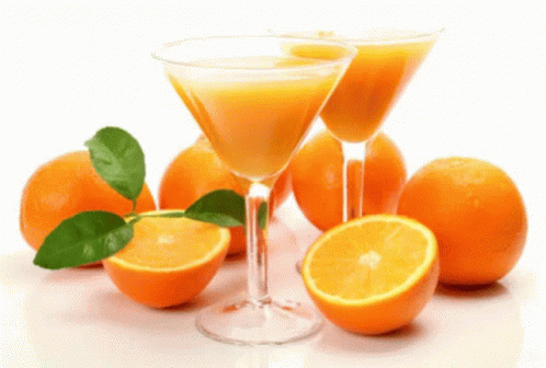 Two Martini Glasses Filled With Orange Juice Are Next To Oranges GIF