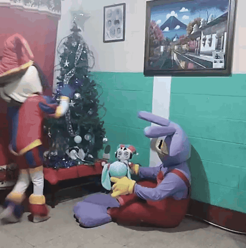 Two Mascots with Stuffed Animal Near Christmas Tree