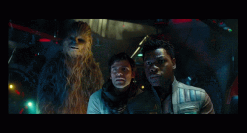 Two Men And A Chewbacca Are Standing In A Dark Room GIF