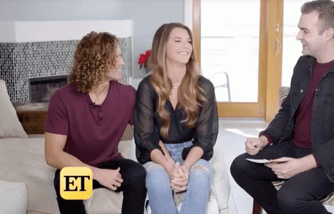 Two Men and Woman Sitting on Couch with ET Logo