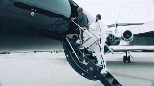 Two Men Are Boarding A Private Jet With The Word Jet On The Side Of It GIF