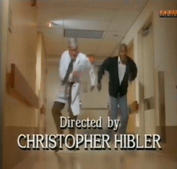 Two Men Are Dancing In A Hallway With A Sign On The Wall That Says Family GIF