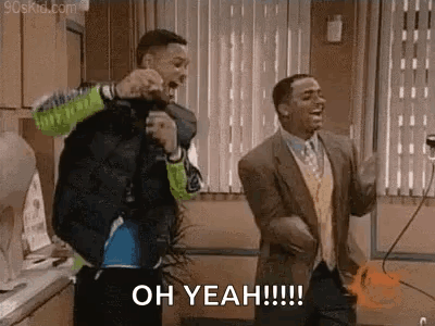 Two Men Are Dancing In A Kitchen And One Of Them Is Holding A Microphone . GIF