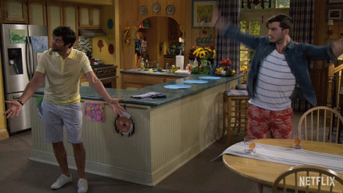 Two Men Are Dancing In A Kitchen With A Sign That Says Eat GIF