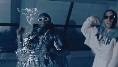 Two Men Are Dancing In Front Of A Window And One Has A Hoodie That Says Amir On It GIF