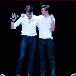 two men are dancing on a stage holding hands