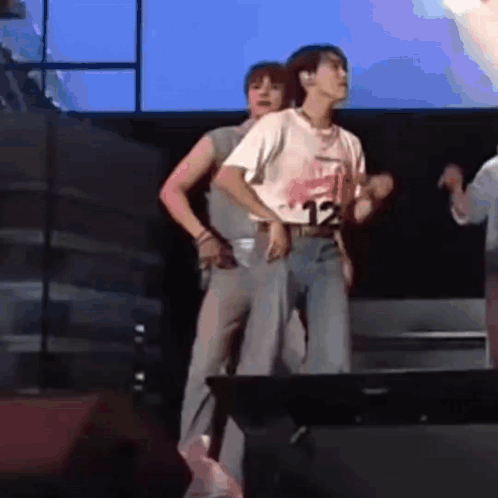 Two Men Are Dancing On A Stage In Front Of A Large Screen . GIF