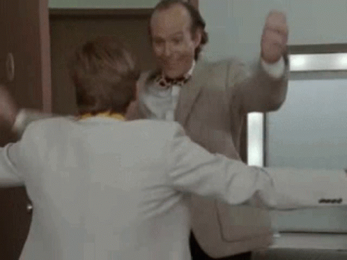 Two Men Are Dancing Together In A Room . GIF