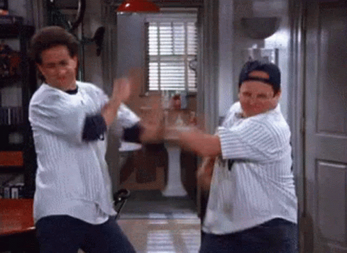 Two Men Are Dancing Together In A Room While Wearing Baseball Jerseys . GIF