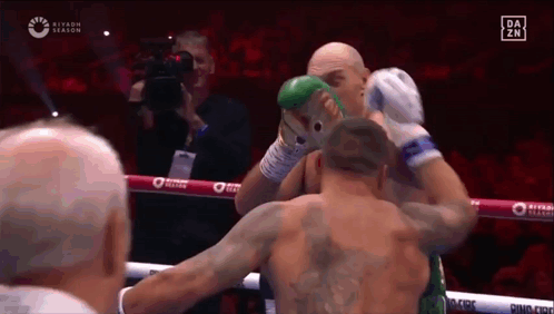 Two Men Are Fighting In A Boxing Ring And One Of Them Has A Tattoo On His Back . GIF