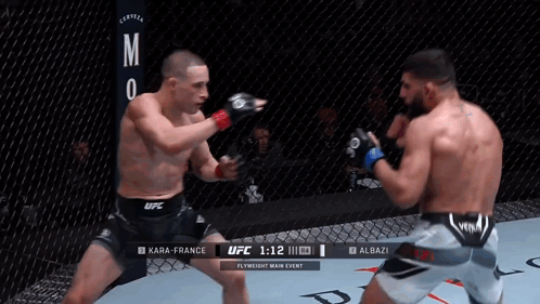 Two Men Are Fighting In A Boxing Ring And One Of Them Is Wearing A Black Ufc Shorts GIF