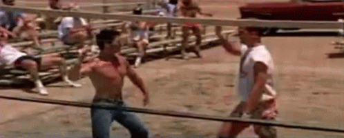 Two Men Are Fighting In A Boxing Ring In Front Of A Crowd Of People . GIF