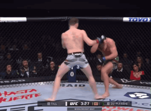 Two Men Are Fighting In A Boxing Ring With The Ufc Logo On The Corner GIF