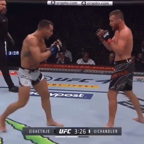 Two Men Are Fighting In A Boxing Ring With The Ufc Logo On The Wall GIF