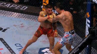 Two Men Are Fighting In A Boxing Ring With The Word Caped On The Wall Behind Them . GIF