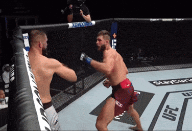 Two Men Are Fighting In A Boxing Ring With Ufc Written On The Side GIF