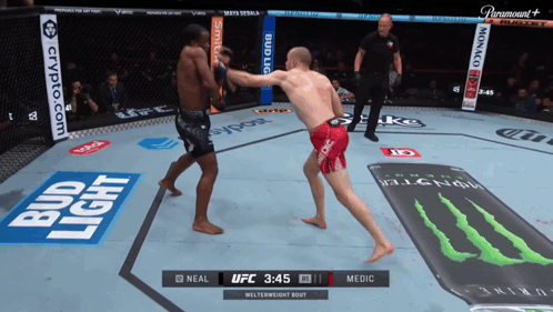 Two Men Are Fighting In A Ring With Bud Light Advertisements GIF