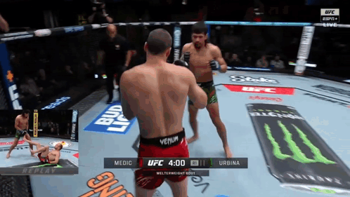 Two Men Are Fighting In A Ufc Ring And One Of Them Is Wearing A Red Venum Shorts GIF