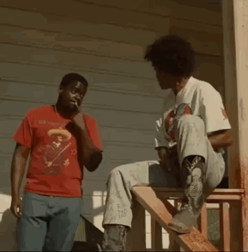 Two Men Are Fighting On A Porch While One Of Them Is Sitting On A Wooden Staircase . GIF