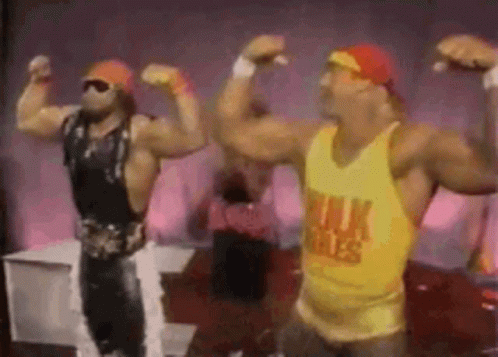 Two Men Are Flexing Their Muscles In Front Of A Pink Wall . GIF