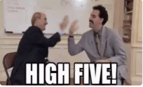 Two Men Are Giving Each Other A High Five In A Room . GIF