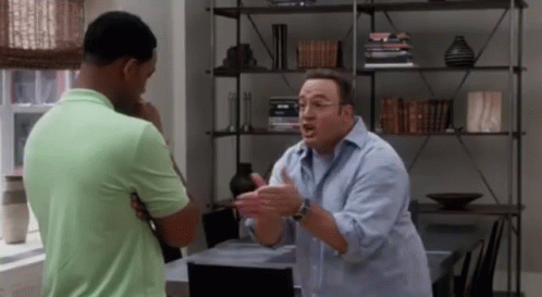 Two Men Are Having A Conversation In A Living Room . GIF