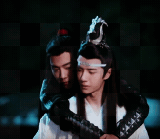 Two Men Are Hugging Each Other And One Has A Crown On His Head GIF