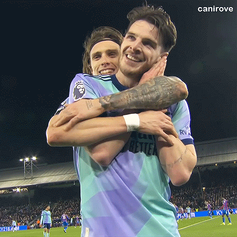 Two Men Are Hugging Each Other On A Soccer Field And One Has A Tattoo On His Arm GIF