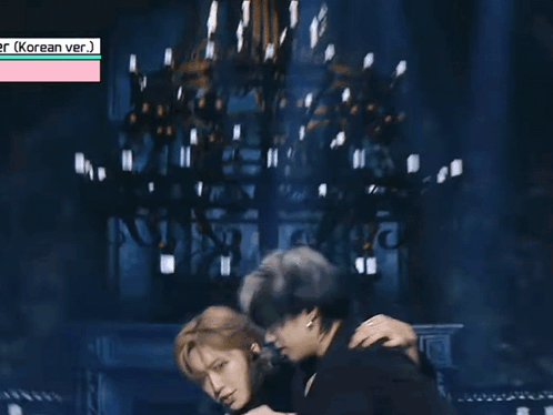 Two Men Are Hugging Each Other On A Stage . GIF