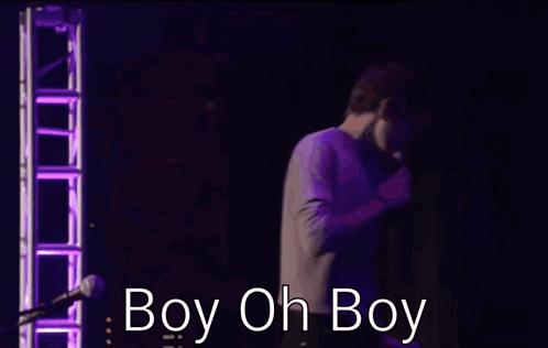 two men are hugging in front of a microphone and the words boy oh boy are visible