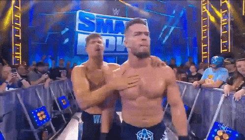 two men are hugging in front of a sign that says ' smackdown '