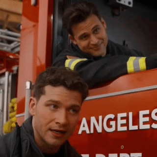 two men are leaning on the side of a fire truck that says angeles