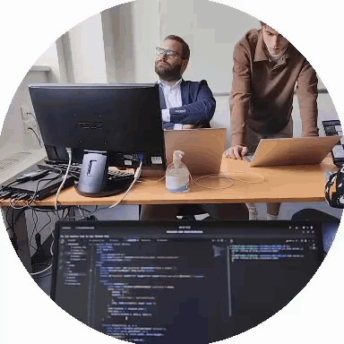 Two Men Are Looking At A Computer Monitor That Says Asus On It GIF