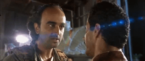 Two Men Are Looking At Each Other And One Has A Beard GIF