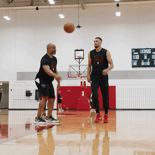 Two Men Are Playing Basketball In A Gym And One Of Them Is Wearing A Bulls Shirt GIF