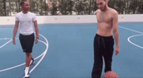 Two Men Are Playing Basketball On A Basketball Court . GIF