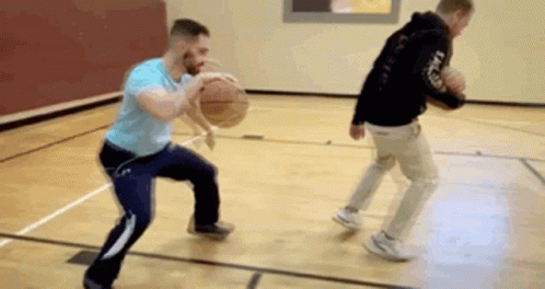 Two Men Are Playing Basketball On A Court And One Is Dribbling The Ball . GIF