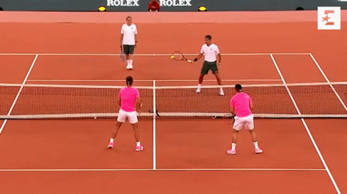Two Men Are Playing Tennis On A Court With Rolex Advertisements On The Wall Behind Them GIF