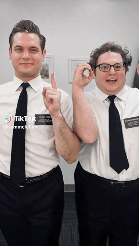 Two Men Are Posing For A Picture And One Has A Name Tag That Says Sammcstellar GIF