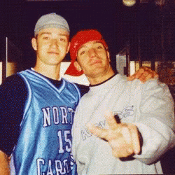 Two Men Are Posing For A Picture And One Is Wearing A North Carolina Jersey GIF