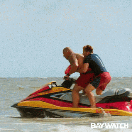Two Men Are Riding A Jet Ski In The Ocean With The Word Baywatch On The Bottom . GIF