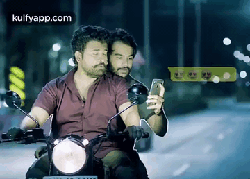 Two Men Riding Motorcycle One Looking At Phone GIF