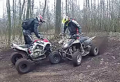 Two Men Riding Four Wheelers On Dirt Road GIF